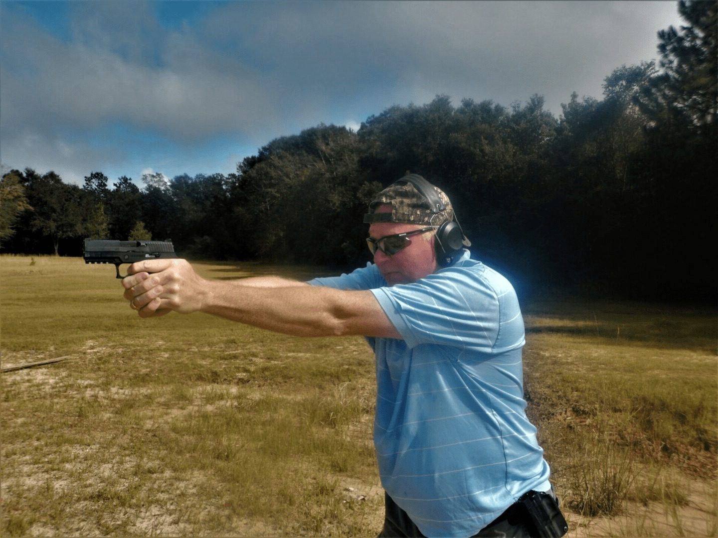 Man shooting a handgun at a range.